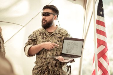 Kamuflaj üniformalı askerler kampta operasyon yapmayı planlıyor.