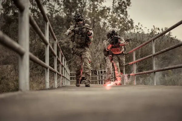 stock image Soldiers  in camouflage uniforms aiming with their rifle