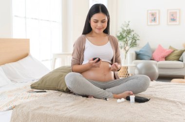 Hamile kadın kan şekerini dijital glikoz ölçer, sağlık bakımı, ilaç, diyabet, glisemi konsepti kullanarak kontrol ediyor.