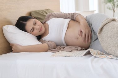 Hamile bir kadın midesi bulanıyor, karnına kramp giriyor, rahatsız..