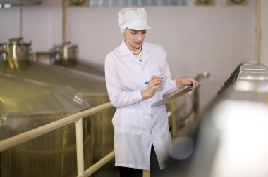 Şarap üretim sürecini ve şarap fabrikasının kalitesini kontrol eden profesyonel şarap üreticisi.