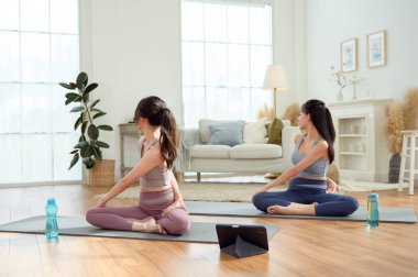 Evde yoga yapan iki genç Asyalı kadın arkadaş.. 