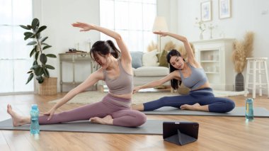 Evde yoga yapan iki genç Asyalı kadın arkadaş.. 