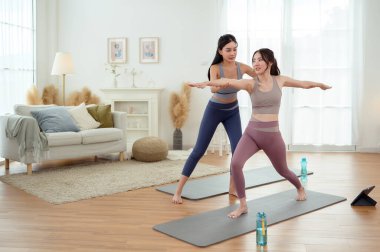 Evde yoga yapan iki genç Asyalı kadın arkadaş.. 