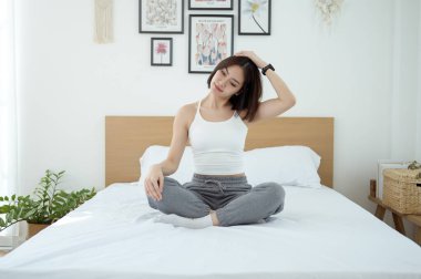 Genç Asyalı kadın yatak odasında egzersiz yapıyor.