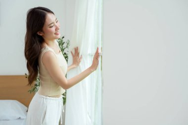 Genç Asyalı kadın sabah ferahlatıyor.