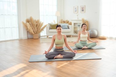 Evde yoga yapan iki genç Asyalı kadın arkadaş.. 