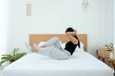 Genç Asyalı kadın yatak odasında egzersiz yapıyor.