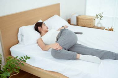 Genç Asyalı kadın yatak odasında egzersiz yapıyor.