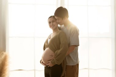 Hamile kadın ve koca portresi, gün batımında siluet, aile ve aşk konsepti.