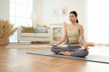 Spor giyinen, yoga yapan Asyalı bir kadın.