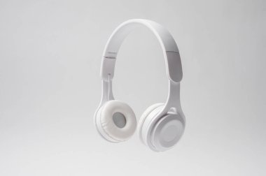 Parlak beyaz kulaklıklar, minimalist tasarım ve konforlarını sergileyerek havada dinleniyor..