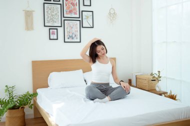 Genç Asyalı kadın yatak odasında egzersiz yapıyor.