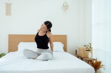 Genç Asyalı kadın yatak odasında egzersiz yapıyor.