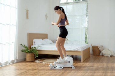 Genç Asyalı sporcu kadın evde bacak egzersizi yapıyor.