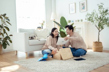 Bir çift neşeli bir şekilde kapalı alandaki bitkileri ve hasır sepetleri, parlak, havadar yaşam alanlarında tutarlar..