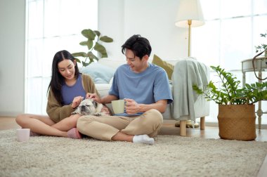 Bir çift köpekleri ile yerde dinlenir, güneşli bir odada hafif bir kahvaltı yaparlar..