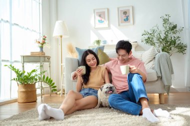 Bir çift köpekleri ile yerde dinlenir, güneşli bir odada hafif bir kahvaltı yaparlar..