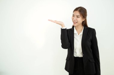 Siyah takım elbiseli kendine güvenen bir kadın kollarını kavuşturup gülümsüyor..