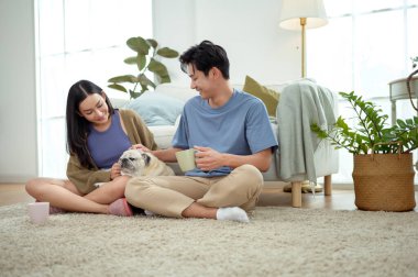 Bir çift köpekleri ile yerde dinlenir, güneşli bir odada hafif bir kahvaltı yaparlar..