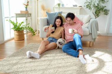 Bir çift köpekleri ile yerde dinlenir, güneşli bir odada hafif bir kahvaltı yaparlar..