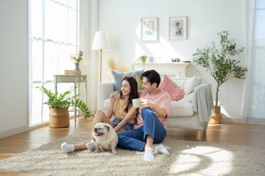 Bir çift köpekleri ile yerde dinlenir, güneşli bir odada hafif bir kahvaltı yaparlar..