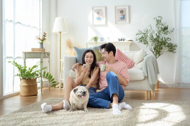 Bir çift köpekleri ile yerde dinlenir, güneşli bir odada hafif bir kahvaltı yaparlar..