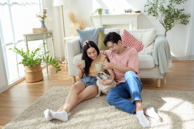 Bir çift köpekleri ile yerde dinlenir, güneşli bir odada hafif bir kahvaltı yaparlar..