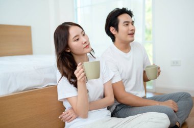 Sabah ışığıyla dolu bir yatak odasında iki kişi kahkaha atıp kahve yudumluyor..