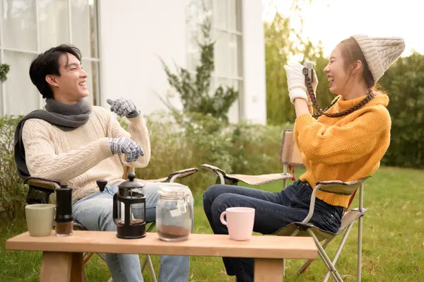 Bir çift bahçede birlikte oturur, kahkahalarla kahkahalar atar ve o anın tadını çıkarırlar..