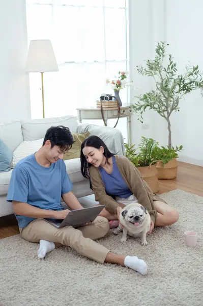 Genç bir çift, köpekleriyle bir kanepede rahatlar. Parlak bir yaşam alanında keyifli anlar paylaşırlar..