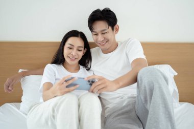 İki insan güler ve sabah güneşinde tablet kullanırken rahat bir anı paylaşır..