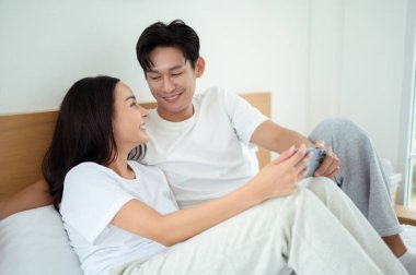 İki insan güler ve sabah güneşinde tablet kullanırken rahat bir anı paylaşır..