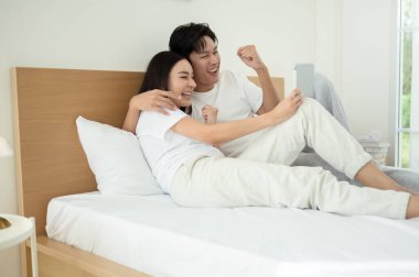 İki insan güler ve sabah güneşinde tablet kullanırken rahat bir anı paylaşır..