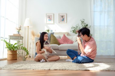 Genç bir çift, köpekleriyle keyifli anlar yakalar. Parlak, rahat bir yaşam alanında..