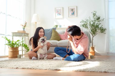 Genç bir çift, köpekleriyle keyifli anlar yakalar. Parlak, rahat bir yaşam alanında..