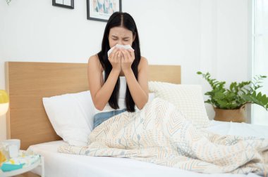 Genç Asyalı kadın yatak odasında hasta hissediyor.