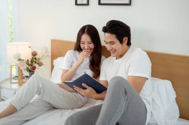 Bir çift beyin fırtınası, bir yatağın üzerine bir deftere yazdığı gibi fikir üretir.