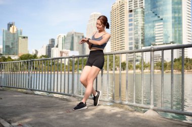 Genç bir kadın şehrin rıhtımındaki spor faaliyetlerini izliyor..