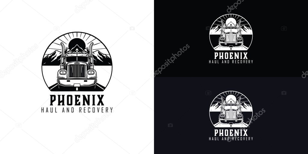 A classic black and white logo for a heavy haul towing company features a powerful semi-truck driving on a road toward a mountain range with the sun in the background.