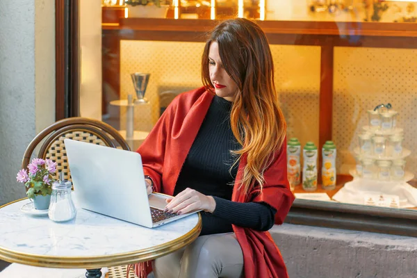 stock image young woman businesswoman sits in a cafe behind a laptop. Business, work online. High quality photo