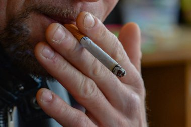 Sigara içen bir adamın ellerinde yakın plan sigara..