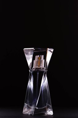 Siyah arka planda cam şişede parfüm