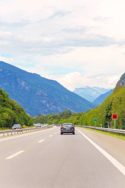 Yüksek dağ sıralarının arka planına karşı asfalt yol.