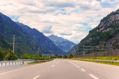 Yüksek dağ sıralarının arka planına karşı asfalt yol.