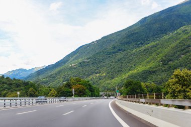 Yüksek dağ sıralarının arka planına karşı asfalt yol.