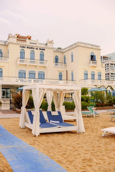 Boş bir sahilde bir sürü kapalı şemsiye ve güneşlik. Sezon konseptini başlat veya sonlandır.