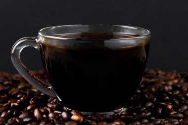 Siyah bir fonda kahve çekirdeği ve kahve fincanı. Mesaj için yer var. Yüksek kalite fotoğraf