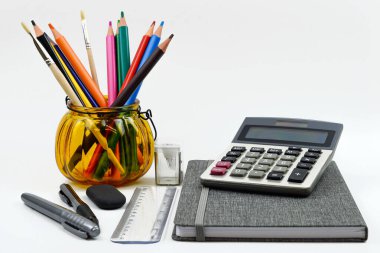 Okul için parlak bir set, beyaz arka planda kırtasiye malzemesi. Renkli kalemler, kalemler, plastik boyalar ve ataçlar, metin için boşluğu olan düz katmanlar.