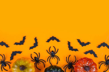 Cadılar Bayramı arka planında balkabakları, örümcekler, yarasalar turuncu bir zemin üzerinde metin için boşluk